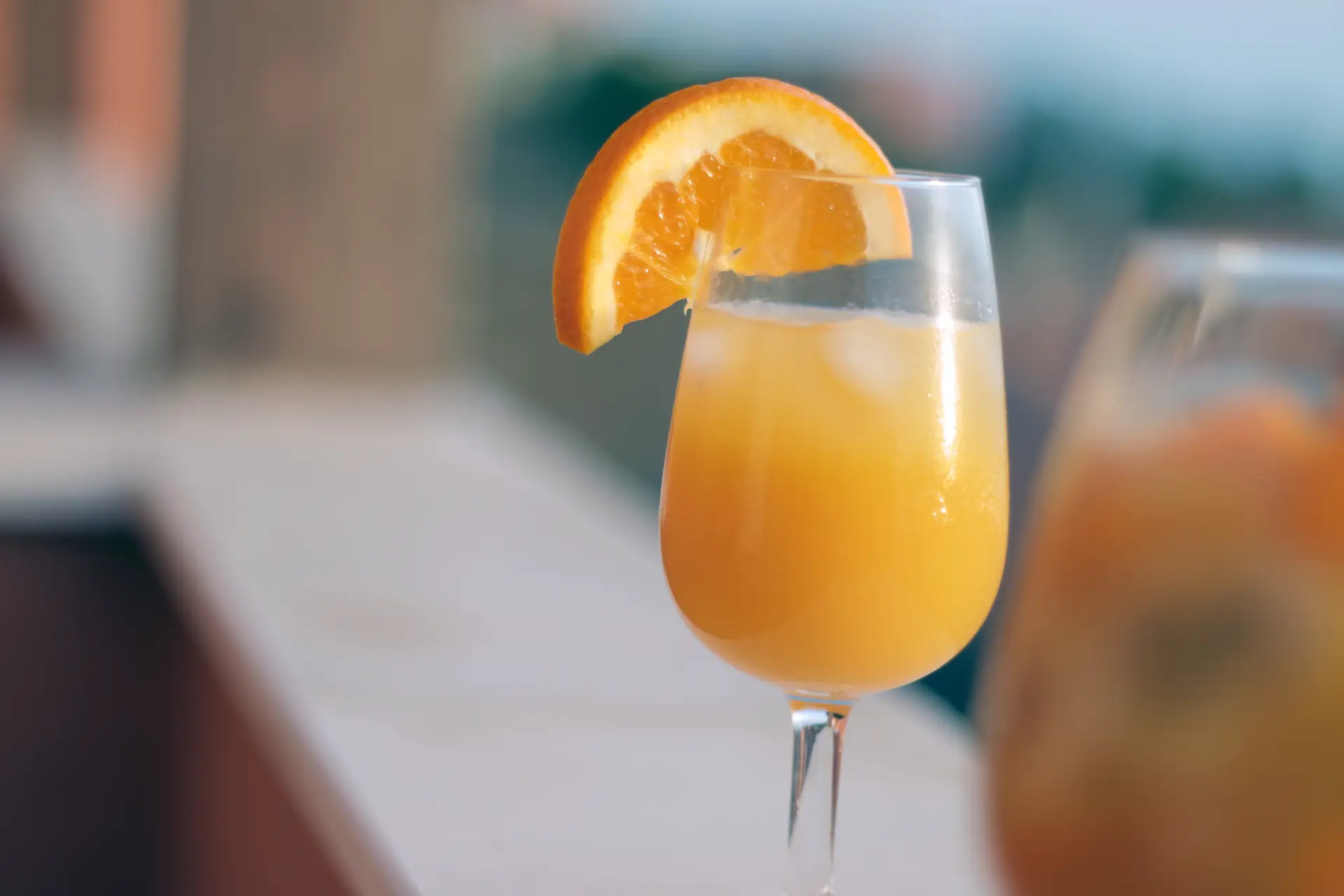 Un mimosa à l’orange pressée, une tranche d’orange sur le bord du verre