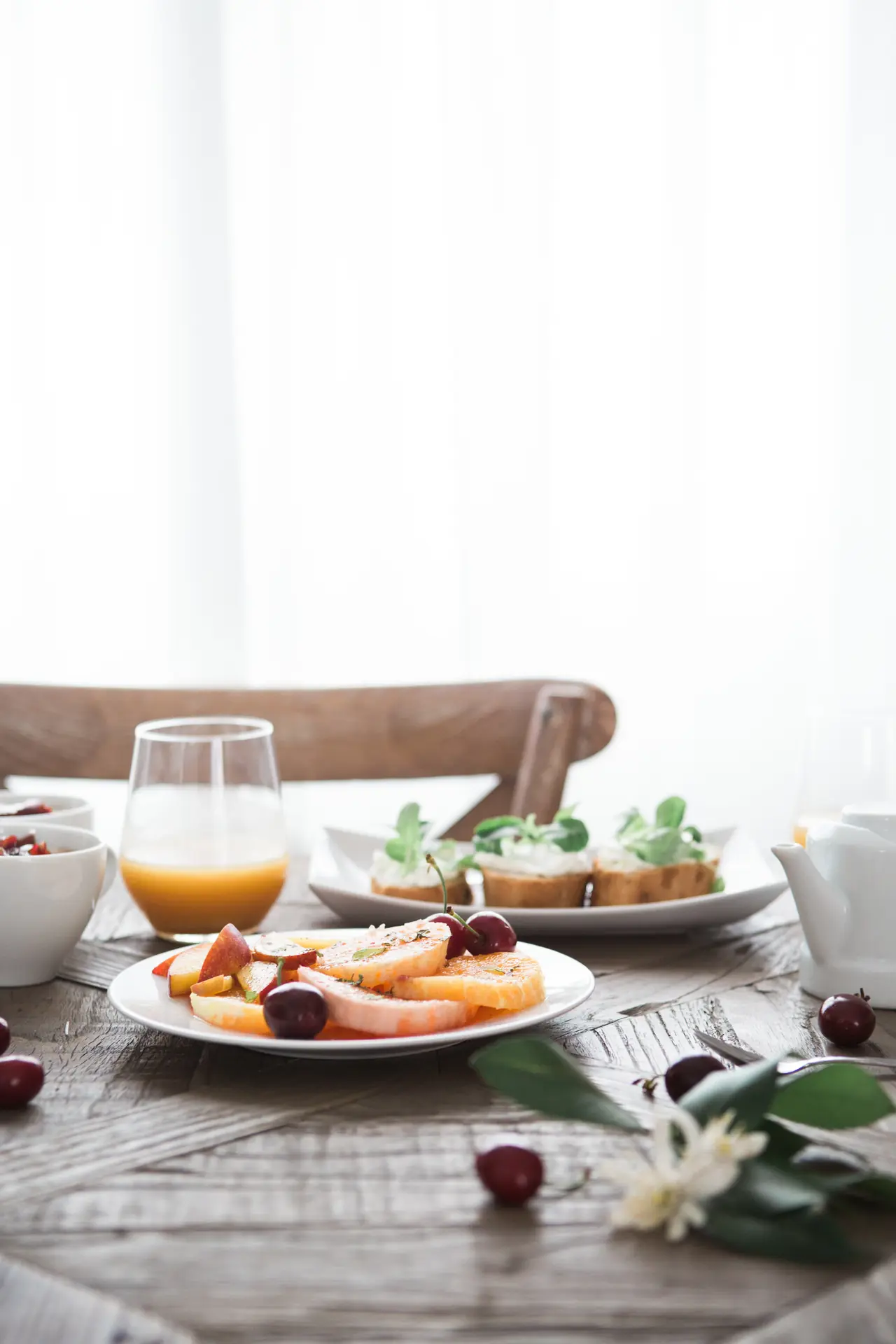 Une table près de la fenêtre au matin, les hortensias bleus du jardin, un bouquet de pivoines, les boules-de-neige blanches, un demi-melon garni sur le guéridon du salon